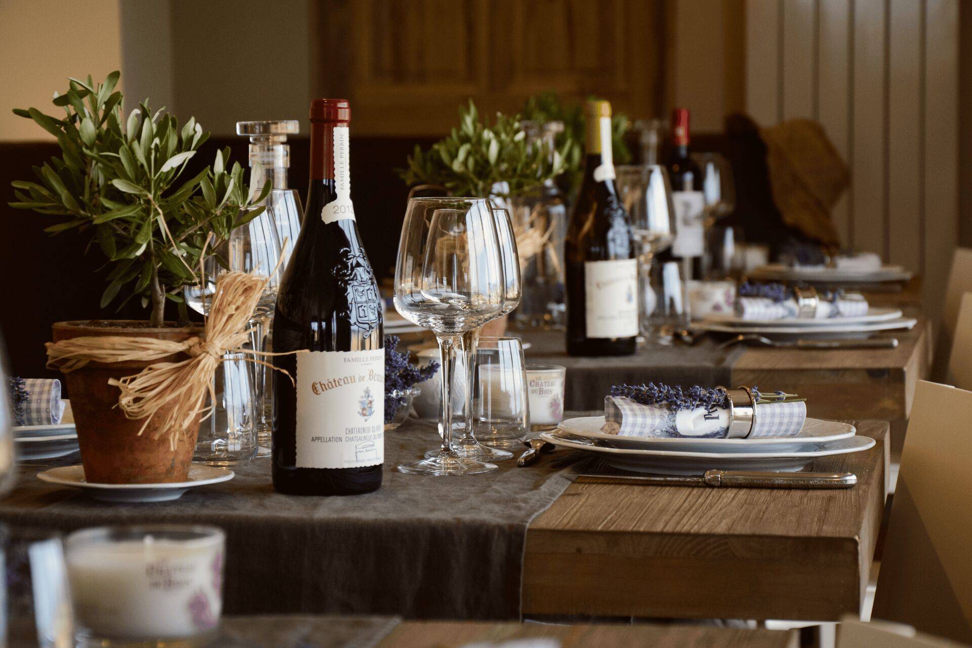 Couverts préparés à la table d'hôtes du Domaine avec des bouteilles sorties de la cave à vins souterraine