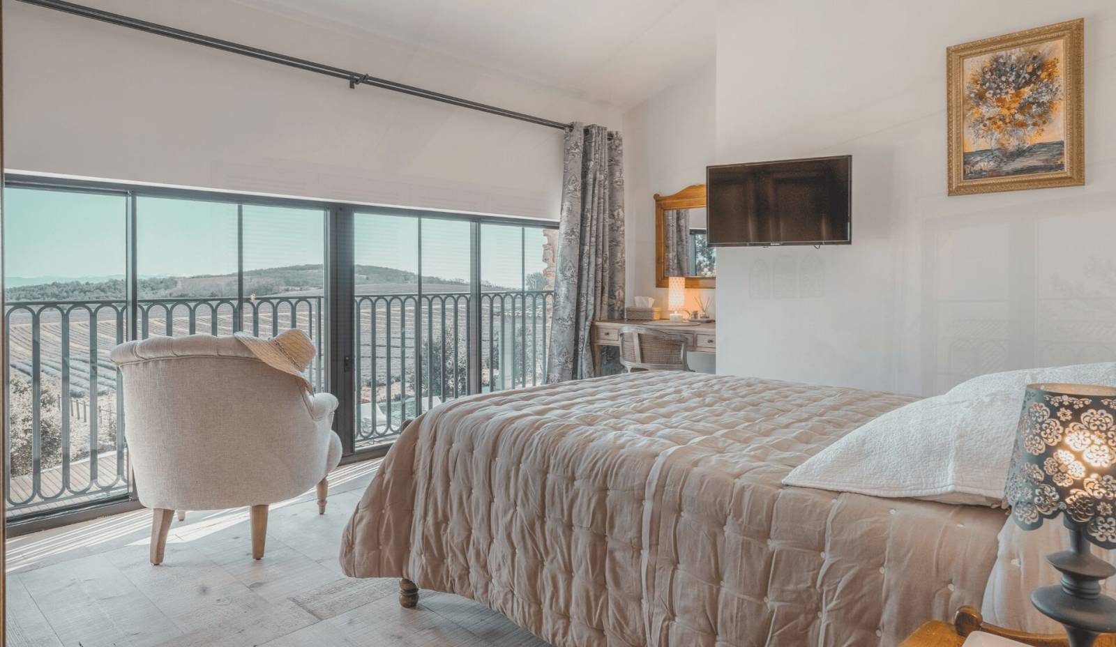 Le lit double de la Chambre Deluxe Elzéar et sa vue sur les champs de lavande fine du Domaine Château du Bois