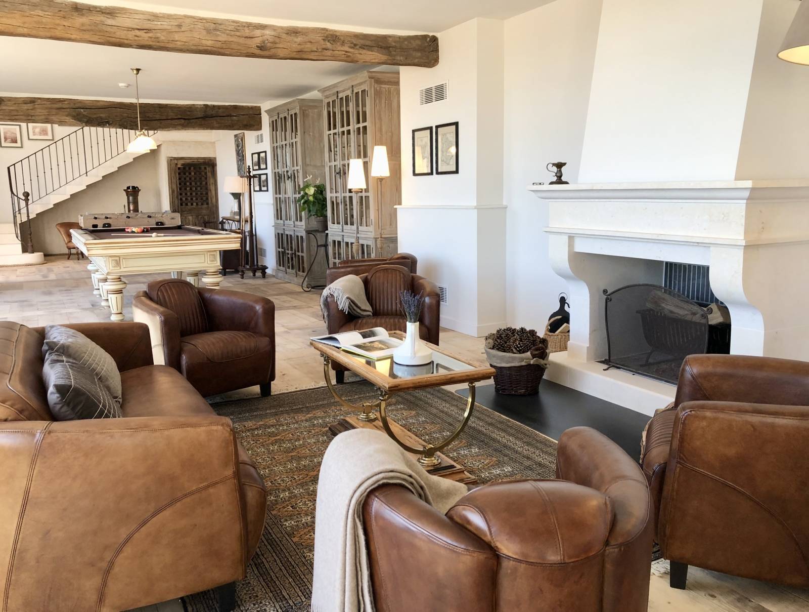 Le salon du Domaine Château du Bois, sa cheminée et ses fauteils en cuir