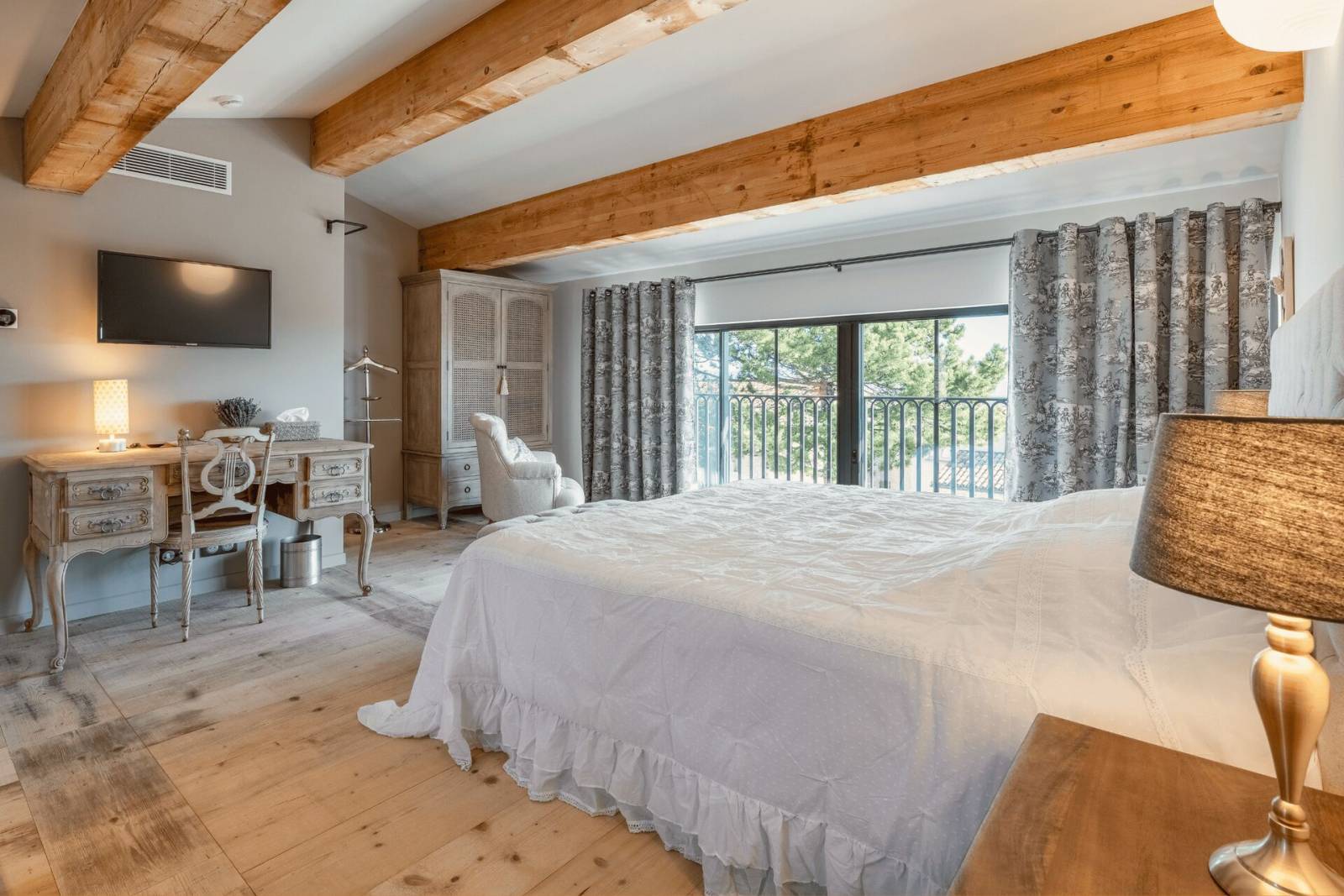 Vue globale d'une des suites du Domaine Château du Bois avec son grand lit