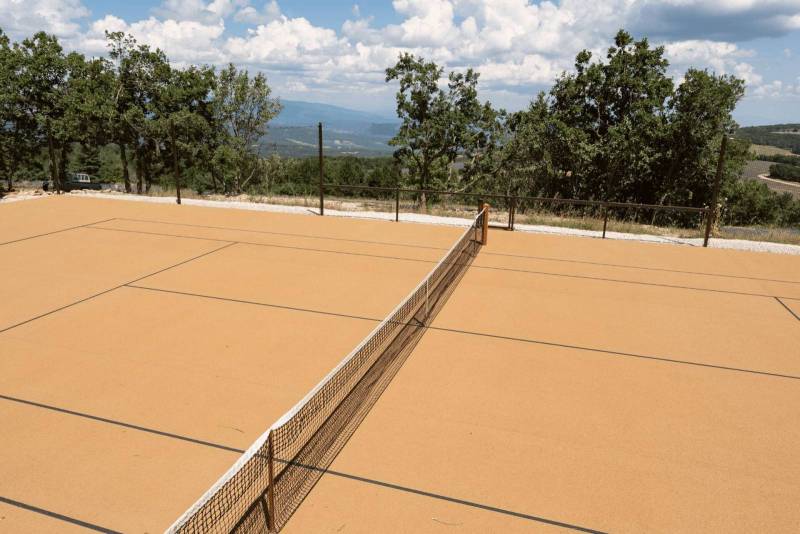 Court de tennis avec vue sur les champs de lavande fine du Domaine Château du Bois et les pré-Alpes