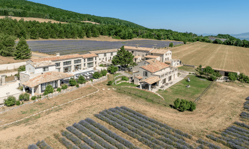 La bâtisse principale du Domaine Château du Bois, sa piscine et les champs de lavande fine