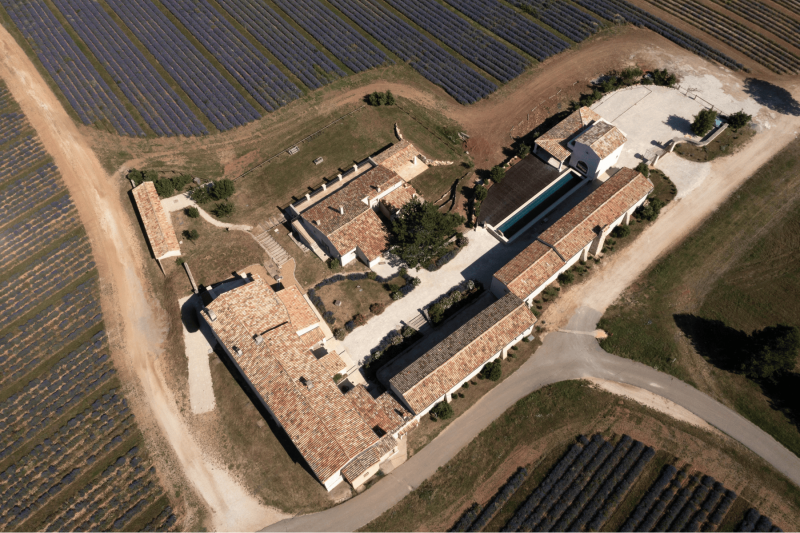 Photo prise en drone des bâtisses du Domaine Château du Bois et des champs de lavande