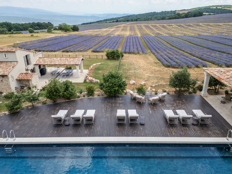 Vue sur la piscine chauffée, la terrasse et les champs de lavande du Domaine Château du Bois