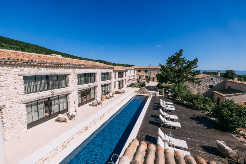 Vue sur la cour intérieure, la piscine et la plage du Domaine Château du Bois