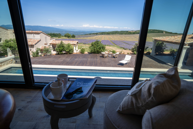Vue sur la piscine et les champs de lavande depuis une des chambres d'hôtes du Domaine Château du Bois
